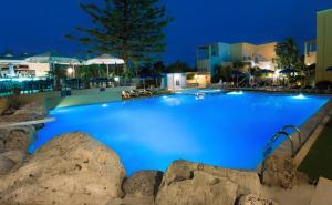 a large swimming pool with blue water at night at Futura Hotel in Maleme +211 photos
