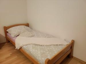 a bed in a room with a white wall at Kerkira Apartment Pale in Pale