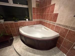 a bath tub in a bathroom with red tiles at Large 3 bedroom house in Nottingham