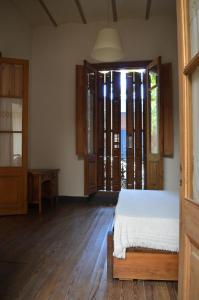ein Schlafzimmer mit einem Bett und einem großen Fenster in der Unterkunft Habitaciones en Casa Céntrica cerca de todo in Colonia del Sacramento