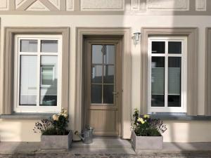 a front door of a house with two windows at Luxus Ferienhaus - Kleine Rosenvilla in Sassnitz