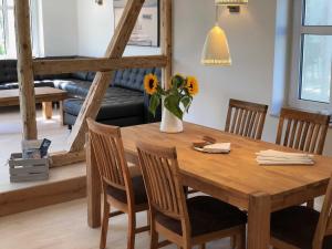 a dining room table with a vase of flowers on it at Luxus Ferienhaus - Kleine Rosenvilla in Sassnitz