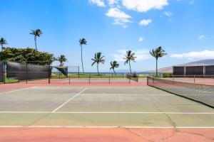een tennisbaan met palmbomen op de achtergrond bij Maui Sunset A513 BY Betterstay in Kihei