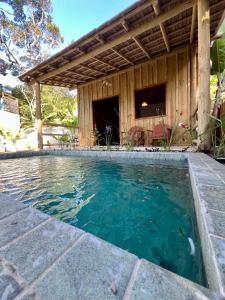 a swimming pool in front of a house at Villa Sagui Trancoso in Trancoso