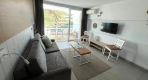 a living room with a couch and a table at Apartment at bronze playa hotel in San Bartolomé de Tirajana