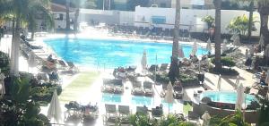 - une vue sur la piscine bordée de chaises et de parasols dans l'établissement Apartment at bronze playa hotel, à San Bartolomé