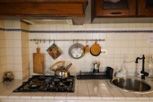 a kitchen counter with a sink and a stove at I Rosai appartamento sulle colline fiorentine in Bagno a Ripoli