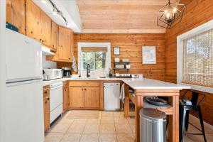 cocina con electrodomésticos blancos y paredes de madera en Cushman Hideaway BY Betterstay, en Hoodsport