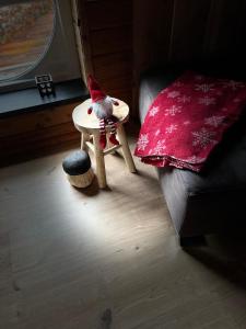 un gnome assis sur une petite table à côté d'un canapé dans l'établissement Gîte Libre’Air, à Redu