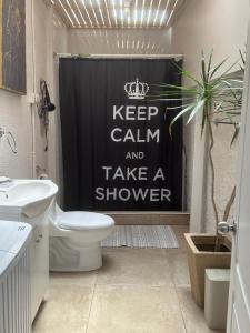 a bathroom with a shower curtain that says keep calm and take a shower at Casa Fuerteventura in Santiago