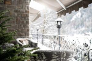 un balcón con mesa, sillas y un árbol de Navidad en Chalet Hotel Hartmann - Adults Only en Ortisei