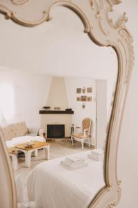ein weißes Wohnzimmer mit einem Sofa und einem Spiegel in der Unterkunft Casa Coração Alentejano- Casas com EnCanto in Reguengos de Monsaraz