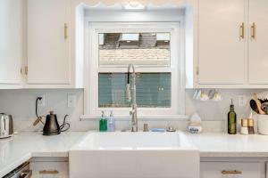 uma cozinha branca com um lavatório e uma janela em Brygger Cottage BY Betterstay em Seattle