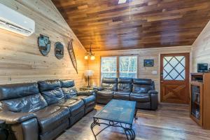 uma sala de estar com mobiliário de couro e paredes de madeira em The Yellow Cabin BY Betterstay em Packwood