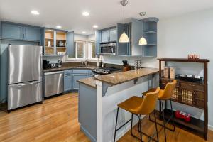 una cocina con armarios azules y electrodomésticos de acero inoxidable en Aurora Abode BY Betterstay en Seattle