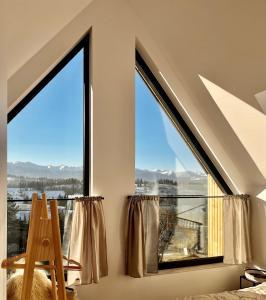 a bedroom with a large window with a view of the mountains at Ponad Górami in Gliczarów Górny