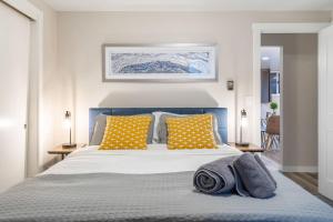 a bedroom with a bed with yellow and blue pillows at Queen Ann Flat BY Betterstay in Seattle