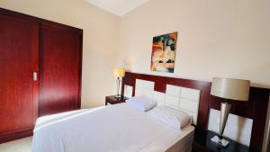 1 dormitorio con cama blanca y cabecero de madera en Dream Royal Residence, en Seis de Octubre
