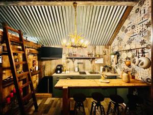 a kitchen with a large wooden table and a chandelier at Tiny House Všemily in Jetřichovice