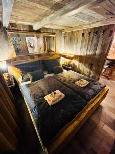 a large bed in a room with wooden walls at Tiny House Všemily in Jetřichovice