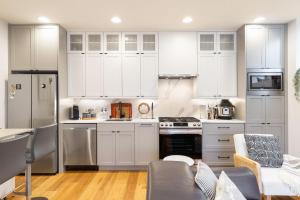 a kitchen with white cabinets and stainless steel appliances at The Ashworth 67 BY Betterstay in Seattle