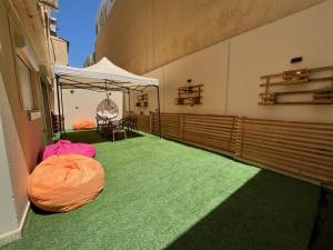 uma varanda com alcatifa verde e uma tenda branca em Charming 2BR with Private Garden no Cairo