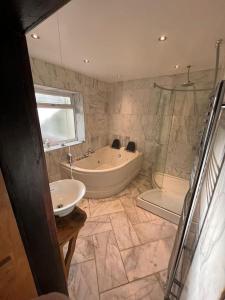 baño grande con bañera y lavamanos en Brownhills, en Eaton