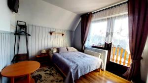 ザコパネにあるWilla Pośredniaのベッドルーム1室(ベッド1台、テーブル、窓付)