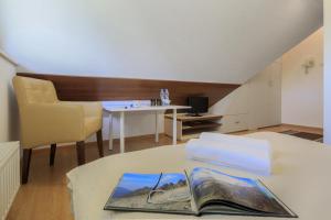 una sala de estar con una mesa con un libro. en Pensjonat Arnika, en Zakopane
