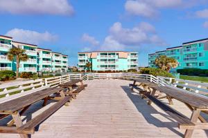 une promenade en bois avec bancs devant les bâtiments dans l'établissement Seaspray 320, à Atlantic Beach