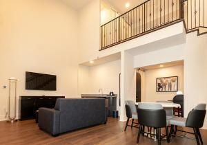 uma sala de estar com um sofá, uma mesa e cadeiras em The Rubenstein Hotel em Nova Orleans