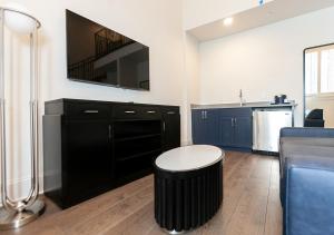 a living room with a black cabinet and a black stool at The Rubenstein Hotel in New Orleans