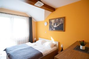 a bedroom with orange walls and a bed and a table at Apartamenty Sadowy in Wisła