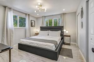 a bedroom with a large bed and two windows at Hallandale Collection - Renovated Professional Design & Lake View in Ro-Len Lake Gardens +36 photos