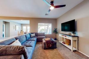 a living room with a blue couch and a flat screen tv at Sweet Home Sherman in Goodyear