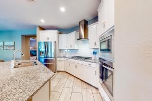 a kitchen with white cabinets and stainless steel appliances at Sweet Home Sherman in Goodyear