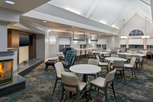 uma sala de jantar com mesas e cadeiras e uma lareira em Residence Inn Greenville-Spartanburg Airport em Greenville