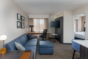 uma sala de estar com um sofá e um quarto com uma cama em Residence Inn Greenville-Spartanburg Airport em Greenville