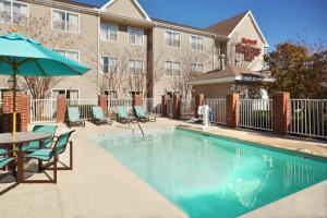 a pool with chairs and a table and an umbrella at Residence Inn Greenville-Spartanburg Airport in Greenville