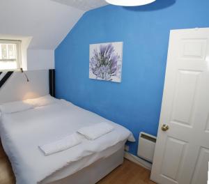a bedroom with a blue wall and a bed at Cozy Old Town Apartment in Nicolson Street in Edinburgh