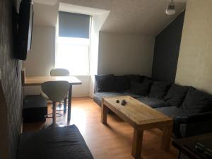 a living room with a couch and a table at Cozy Old Town Apartment in Nicolson Street in Edinburgh