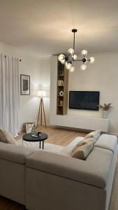 uma sala de estar com um sofá e uma televisão de ecrã plano em Gjirokastra Design Apartments em Gjirokastër