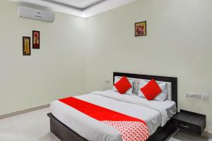 um quarto com uma cama grande e almofadas vermelhas em Super OYO Flagship A R V Palace em Lucknow