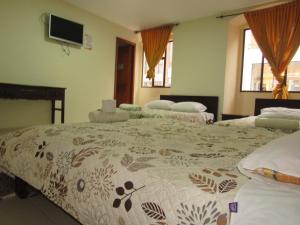 HOTEL COLONIAL في إبياليز: غرفة نوم بسريرين وتلفزيون على الحائط