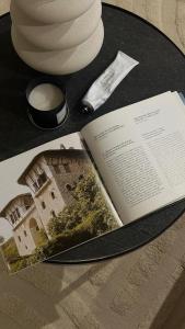 um livro aberto sobre uma mesa com uma chávena de café em Gjirokastra Design Apartments em Gjirokastër