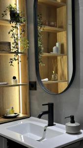 a bathroom with a sink and a mirror at Gjirokastra Design Apartments in Gjirokastër