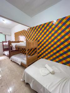 um quarto com duas camas e uma parede colorida em pousada Vitoria em Morro de São Paulo