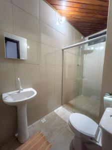 uma casa de banho com um WC, um lavatório e um chuveiro em pousada Vitoria em Morro de São Paulo
