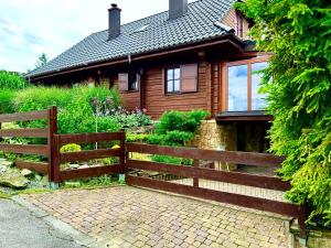 una casa de madera con una valla delante en Górski Azyl w Soblówce en Sablówka