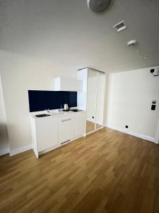 een lege kamer met een witte keuken en een houten vloer bij Orbi city Twin Towers in Batoemi